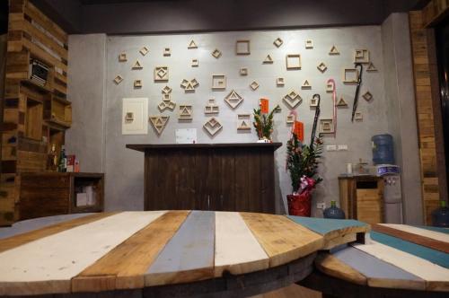 a wooden table in a room with a wall withaques at 馬公港精品旅宿包棟烤肉附設租車 in Magong