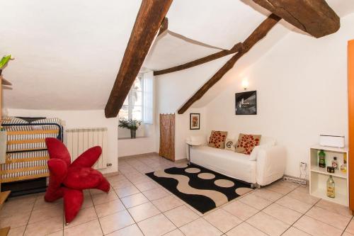 uma sala de estar com uma cadeira vermelha e um sofá em Palazzo Saluzzo Paesana Beautiful Flat em Turim