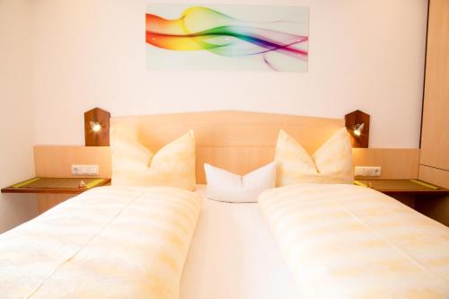 a bedroom with two beds and a painting on the wall at Haus Tirol in Kappl