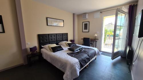 ein Schlafzimmer mit großem Bett und Balkon in der Unterkunft ALYSA in Parthenay