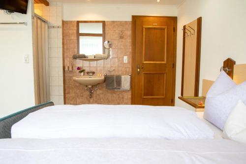 a bedroom with a white bed and a sink at Haus Tirol in Kappl