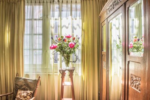 un jarrón de flores en una mesa junto a una ventana en Studio Koggeschip, en Ámsterdam