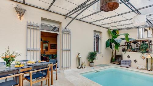 une terrasse avec une piscine, une table et des chaises dans l'établissement Cocoon in Cannes *****, à Cannes