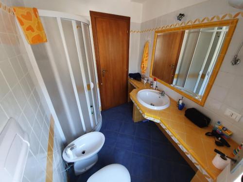 uma casa de banho com um WC, um lavatório e um espelho. em IKEA em Piraino