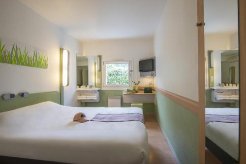 ヴァロリスにあるibis budget Antibes Sophia Antipolisのベッド2台とバスルームが備わるホテルルームです。