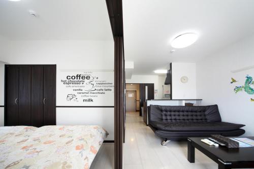 1 dormitorio con cama, sofá y mesa en EX Itoman Apartment 603 en Itoman
