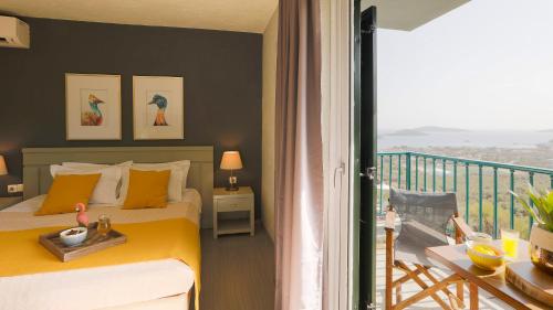 a bedroom with a yellow bed and a balcony at Vigles Sea View, Philian Hotels and Resorts in Skiathos Town