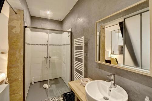 une salle de bain avec une douche, un lavabo et un miroir dans l'établissement L'Atelier d'Auguste - Terrasse en plein cœur de Bordeaux, à Bordeaux