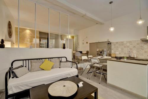 Il comprend un salon et une cuisine avec un lit et une table. dans l'établissement L'Atelier d'Auguste - Terrasse en plein cœur de Bordeaux, à Bordeaux