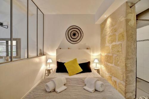 une chambre avec un grand lit avec deux oreillers dans l'établissement L'Atelier d'Auguste - Terrasse en plein cœur de Bordeaux, à Bordeaux