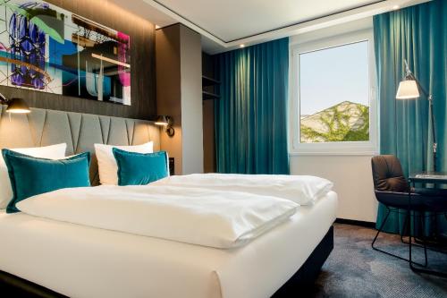 a hotel room with a large bed and a window at Motel One Berlin-Hackescher Markt in Berlin