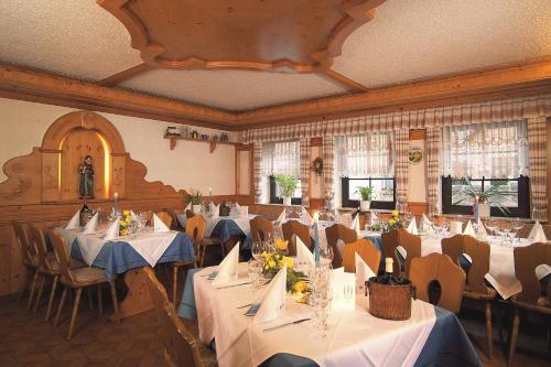 a dining room with tables and chairs with white table cloth at Landgasthof Hotel Grüner Baum in Nürnberg