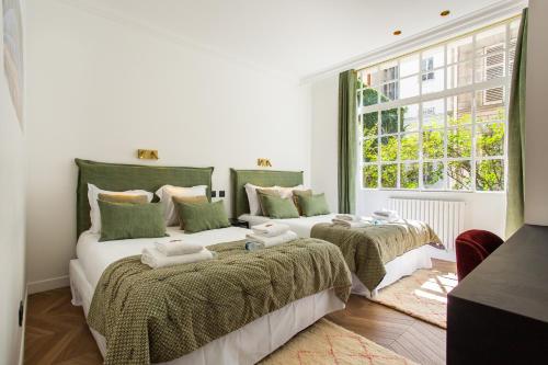 Duas camas num quarto com uma janela em CMG - Le Bon Marché - Sèvres G em Paris