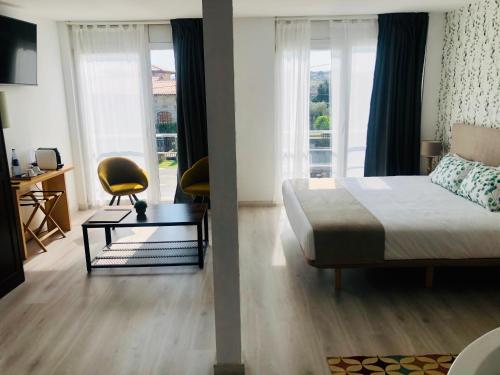1 dormitorio con 1 cama, escritorio y ventanas en Hotel Finca Alcamino en Mompía