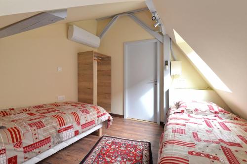 a bedroom with two beds and an open door at Chez Madeleine in Châtenois