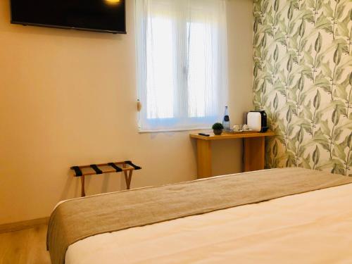 a bedroom with a bed and a window and a television at Hotel Finca Alcamino in Mompía