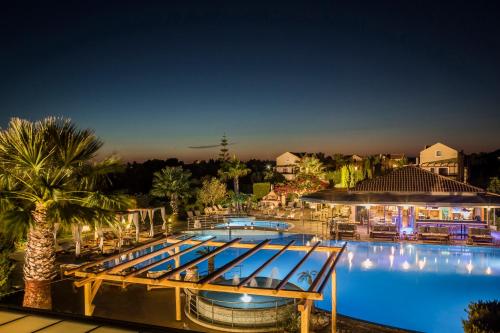 a large swimming pool with a resort at night at Avithos Resort Hotel in Svoronata