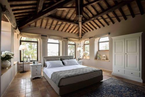 - une chambre avec un grand lit dans une pièce dotée de fenêtres dans l'établissement Villa Teloni, à San Severino Marche