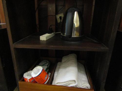 a cupboard with a coffee maker and towels in it at Lawu Forest Camp in Sarangan