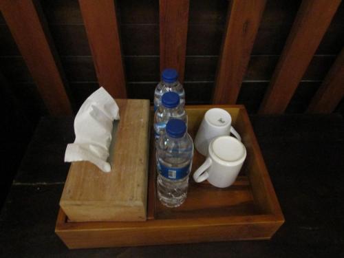 a bottle of water and toilet paper on a wooden tray at Lawu Forest Camp in Sarangan