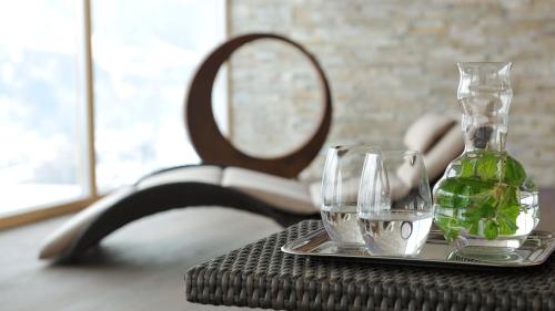 a table with two glasses and a vase on a tray at Hotel Ritzlerhof - Panorama und Spa in Sautens