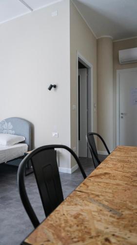 a room with a table and chairs and a bed at Piccolo Catalunya Hostel in Alghero