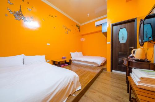 a hotel room with two beds and a tv at Chang-an House B&B in Hualien City