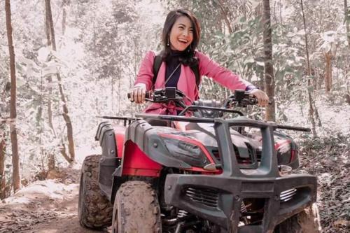 a woman riding a atv in the woods at Lawu Forest Camp in Sarangan