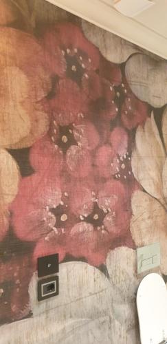 a wall with red flowers painted on it at Palazzo 42 - Boutique Hotel & Suites in Pistoia