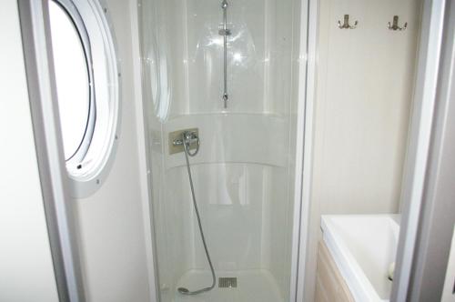 a shower with a glass door in a bathroom at MHVACANCES LOUENT PLUSIEURS MOBILHOMES DANS CAMPING 4 ETOILES PROCHE CHATEAUX et ZOO BEAUVAL in Onzain