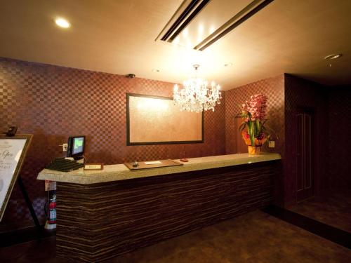 a bar in a hotel room with a chandelier at Hotel Fine Garden Matsuzaka III in Matsuzaka