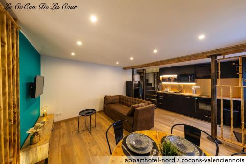 a living room with a couch and a table at Le CoCon De La Cour in Valenciennes