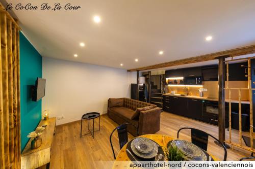 un salon avec un canapé et une table dans l'établissement Le CoCon De La Cour, à Valenciennes