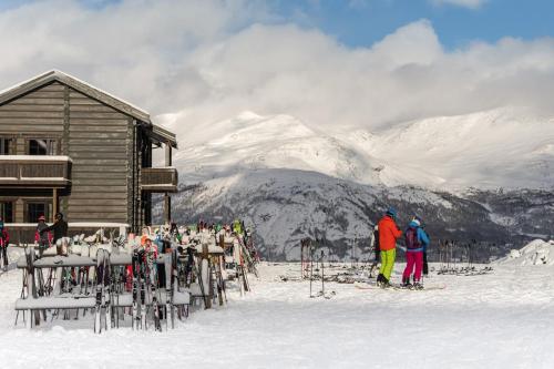 grupa osób stojących przed domkiem narciarskim w obiekcie Skigaarden w mieście Hemsedal