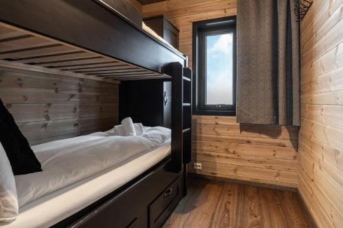 a bedroom with two bunk beds and a window at Skigaarden in Hemsedal