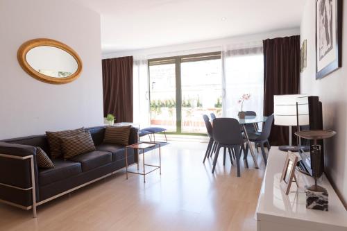 ein Wohnzimmer mit einem schwarzen Sofa und einem Tisch in der Unterkunft Plaza Catalunya City Center Apartments in Barcelona