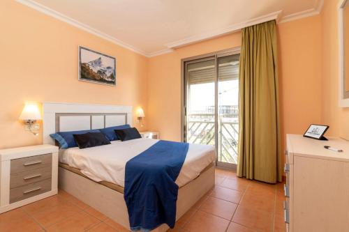 a bedroom with a bed and a large window at HomeForGuest Spacious and bright flat on the beach La Tejita in Granadilla de Abona