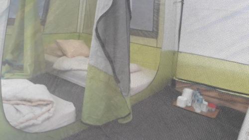 a room with a cage with a bed and towels at Lawu Forest Camp in Sarangan