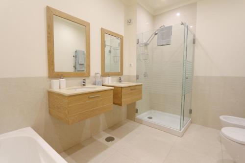 een badkamer met twee wastafels en een glazen douche bij Villa Casa da Luz, Palmyra 173 - Clever Details in Vilamoura