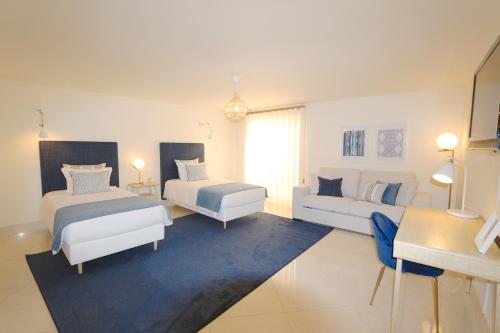 een grote witte kamer met 2 bedden en een bank bij Villa Casa da Luz, Palmyra 173 - Clever Details in Vilamoura