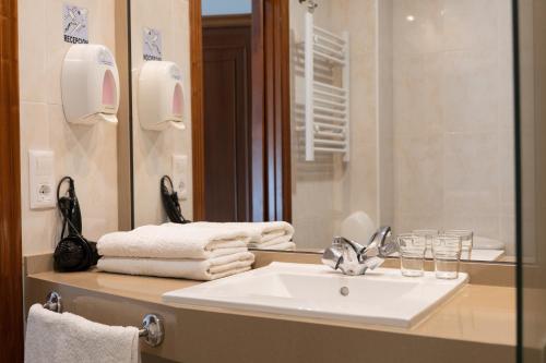 a bathroom with a sink and a mirror at Hotel Carlos 96 in Melide