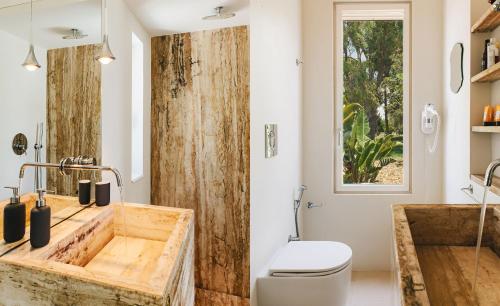 bagno con lavandino in legno e servizi igienici. di Villa Calipso - Homelike Villas a Nardò