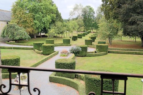 a view of a garden with hedges and a fence at Château du Bû in Anctoville