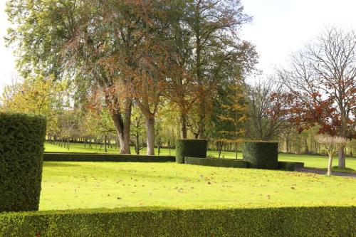a park with hedges and trees in a field at Château du Bû in Anctoville