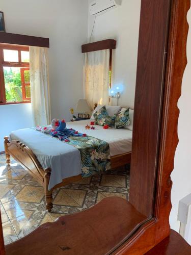 a bedroom with a bed with a mirror on it at Orchid Sunset Guest House in Baie Lazare Mahé