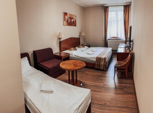 a hotel room with two beds and a table at Kolštejn wellness centrum in Branná