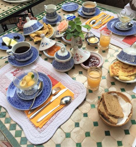 a table topped with blue and white plates of food at Riad Norma in Fès