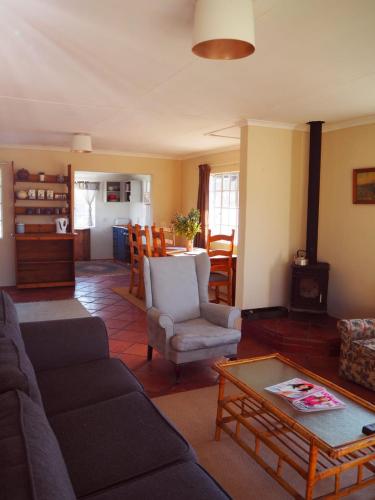 una sala de estar con un sofá y una mesa en Riverview Country Inn, en Van Reenen