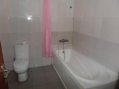 a bathroom with a white tub and a toilet and a sink at Alluring View Hotel - Toyin Sreet in Ikeja