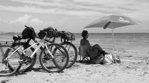 a man sitting on the beach under an umbrella at Hotel Arce in San Pedro del Pinatar